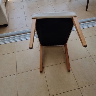 כיסא הפוך עם ריפוד בהיר על רצפת אריחים