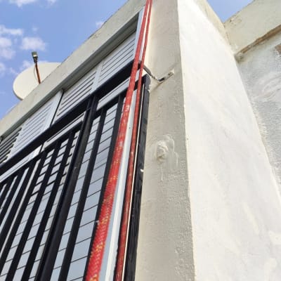 צינור אדום מחובר לקיר לבן עם איטום