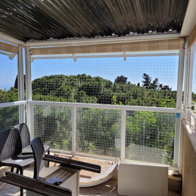 רשת למניעת כניסת יונים במרפסת עם כיסאות פלסטיק