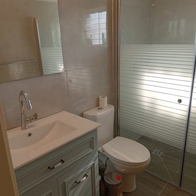 חדר אמבטיה עם כיור, אסלה ומקלחון חדש.