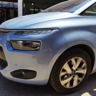 חזית רכב כחול עם פנס קדמי וגלגל