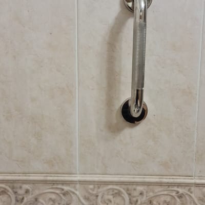 ידית אחיזה מתכתית על קיר אריחים