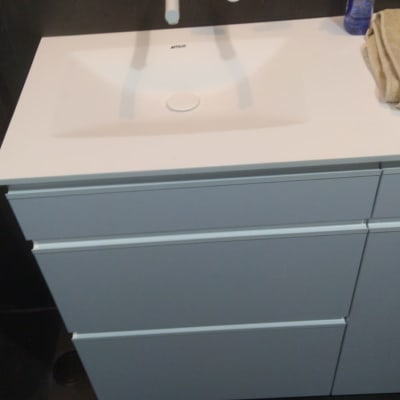 כיור לבן עם ברזים עליונים ומגירות מתחת