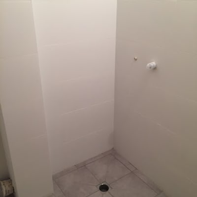 חדר אמבטיה עם אריחים חדשים וניקוז ברצפה