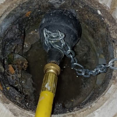 צינור צהוב מחובר לפתח ניקוז עם שרשרת