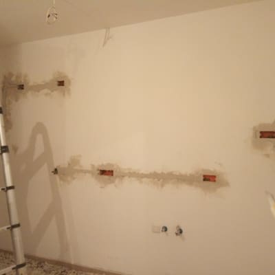 קיר עם שקעים חשמליים פתוחים וסולם מתכת