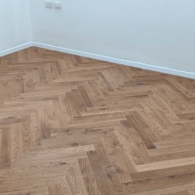 רצפת פרקט עץ בדוגמת פישבון בחדר ריק