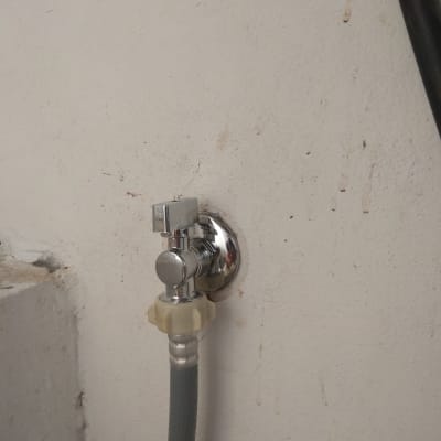 ברז מים עם צינור מחובר לקיר
