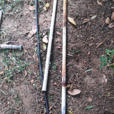 צינורות חלודים על אדמה עם עלים יבשים