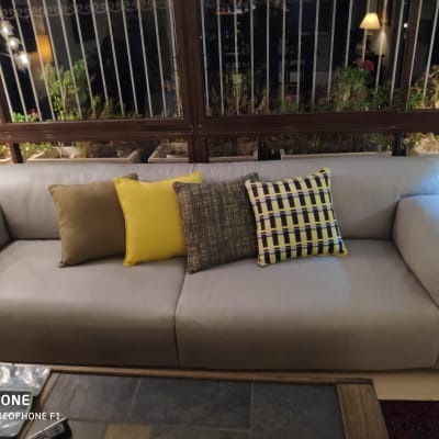 כריות צבעוניות על ספה אפורה בסלון מואר