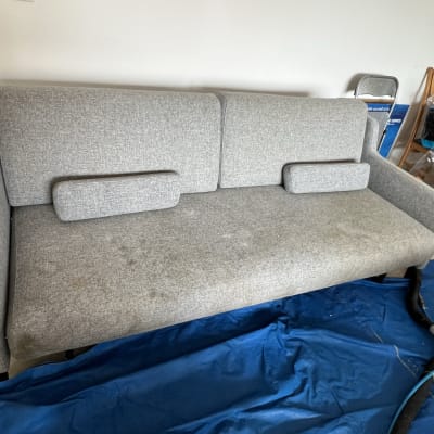 ספה אפורה עם כתמים על יריעת פלסטיק כחולה