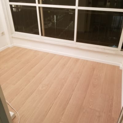 רצפת פרקט עץ בהירה ליד חלון גדול