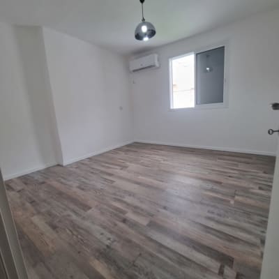 חדר עם רצפת פרקט חדשה ותאורה מותקנת