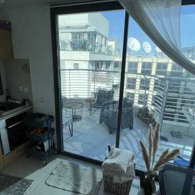 תריסים זכוכית גדולים עם וילון לבן בצד