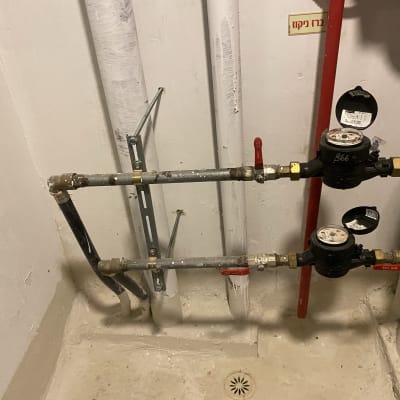 צינורות מים עם ברזים ומדי מים בחדר שירות