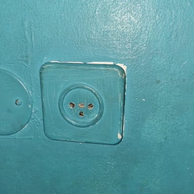 שקע חשמלי ישן על קיר צבוע בכחול