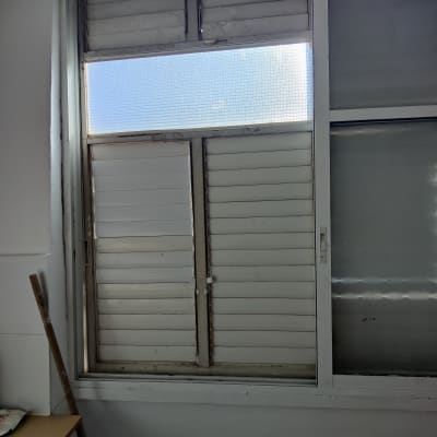 תריסים לבנים סגורים עם חלון זכוכית עליון