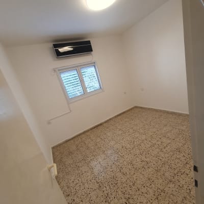 חדר ריק עם רצפה נקייה וקירות לבנים