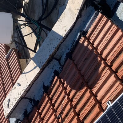 איטום גג עם חומר שחור בין רעפים