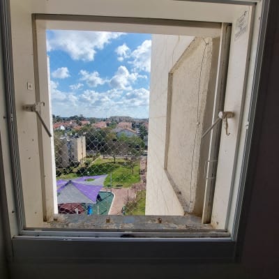 רשת נגד יונים מותקנת על חלון פתוח