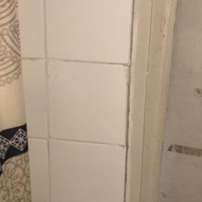 קיר אריחים לבנים ודלת עם ידית מתכת