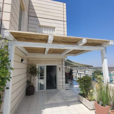 פרגולה מעץ עם צמחים בעציצים על מרפסת