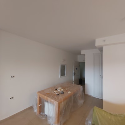 שולחן מכוסה בניילון עם כלי עבודה לצביעת קירות