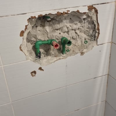 צנרת ירוקה בקיר פתוח עם חיבורים