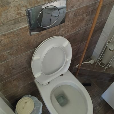 אסלה עם לחצן הדחה על קיר אריחים