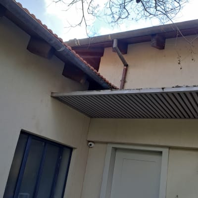 גג רעפים עם מרזב מתכת ועץ חשוף