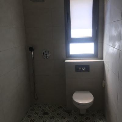 מקלחת ושירותים עם אריחים חדשים על הרצפה