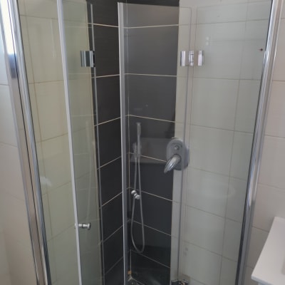 מקלחון עם דלתות זכוכית ומקלחת עליונה