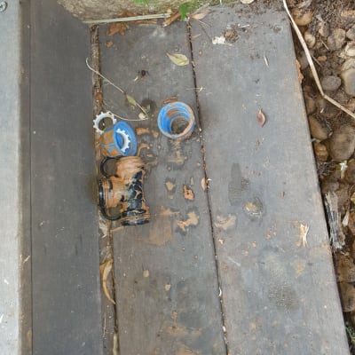 חלקי צנרת פלסטיק שבורים על רצפת עץ