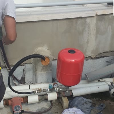 צנרת עם מיכל אדום ומד לחץ על גג