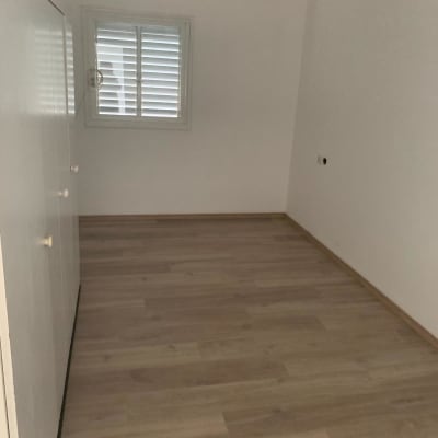 חדר עם רצפת פרקט חדשה וקירות צבועים