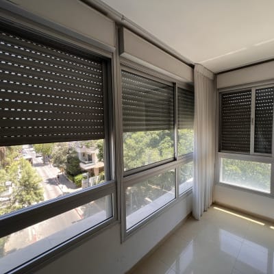 תריסים סגורים על חלונות זכוכית בחדר מואר