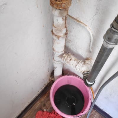 צינור חלוד ודלי ורוד עם מים כהים