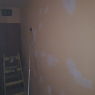 קיר עם תיקוני צבע וסולם צהוב