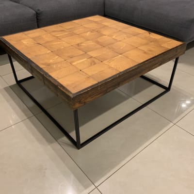 שולחן עץ עם מסגרת מתכת שחורה על רצפה בהירה