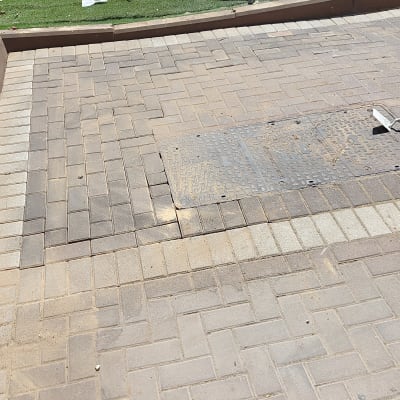 כלי עבודה ושקית על דשא מלאכותי ליד מדרכה