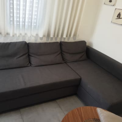 ספה אפורה עם כריות בסלון מואר