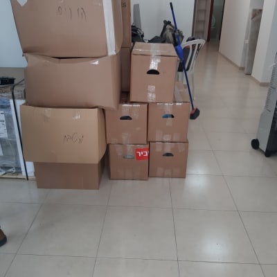 קופסאות קרטון מסודרות בערימה עם מטאטא בצד