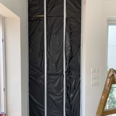 קיר גבס עם יריעות פלסטיק שחורות ומסגרת מתכת