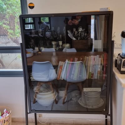 ארון זכוכית עם כוסות וצלחות בפנים