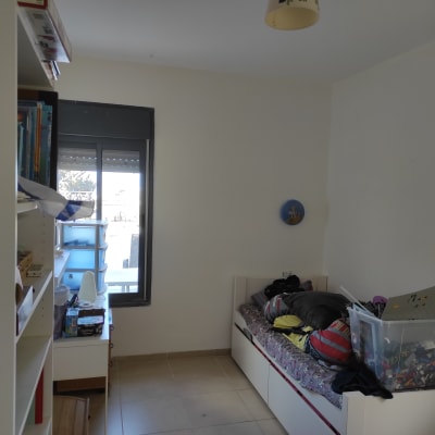 חדר עם מיטה, מדפים, קופסת צעצועים וחלון