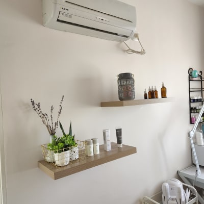 מדף עץ עם צמחים ומוצרי טיפוח מתחת למזגן
