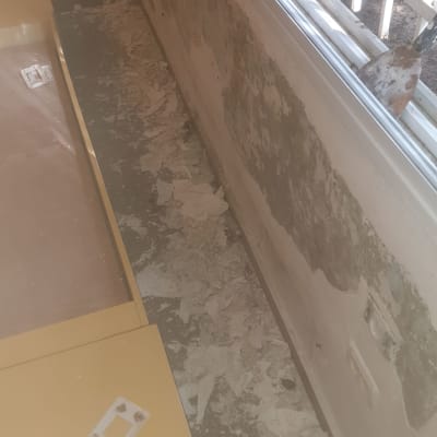 קיר מתקלף ליד חלון עם סימני רטיבות