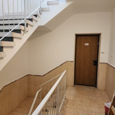 סולם עם מברשות ודלי צבע במסדרון