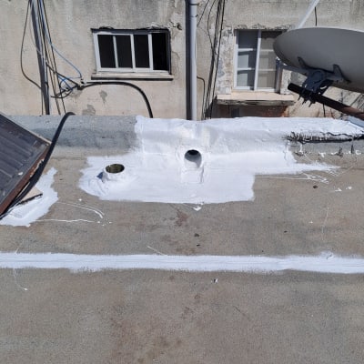 גג עם צינורות וכתמי צבע לבן