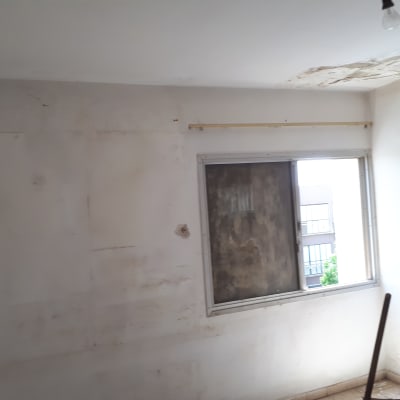 קיר מתקלף עם סימני רטיבות ליד חלון